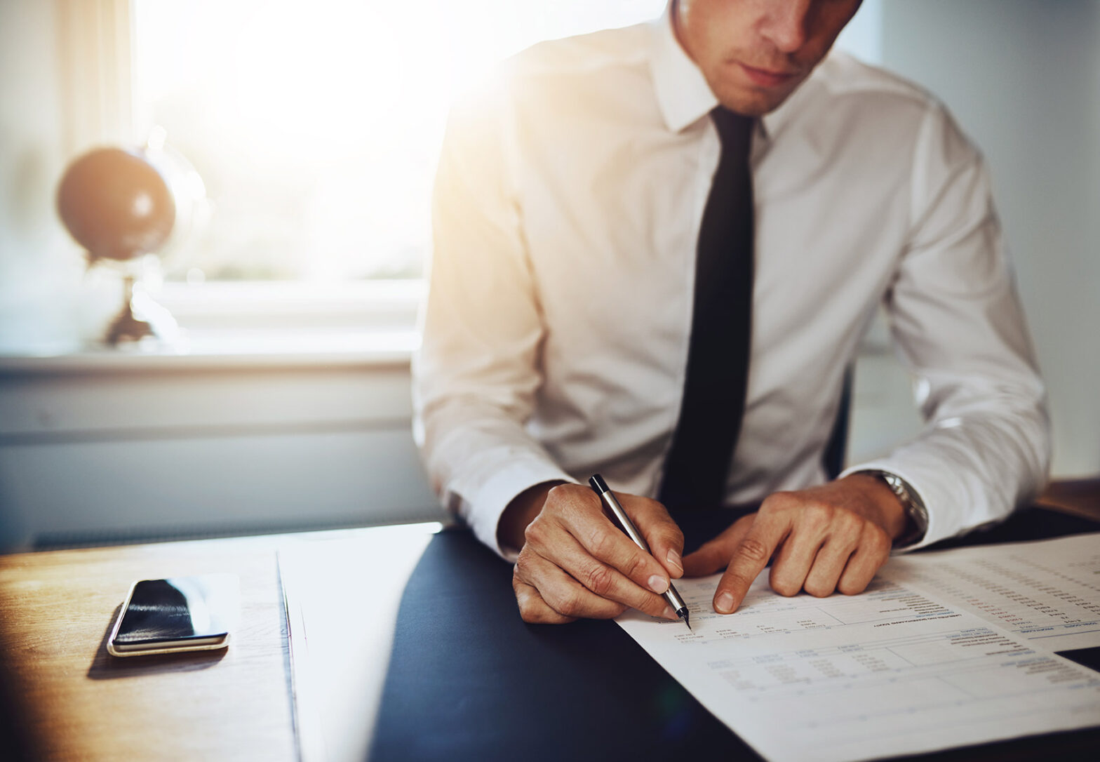 business man reviewing printed spreadsheets